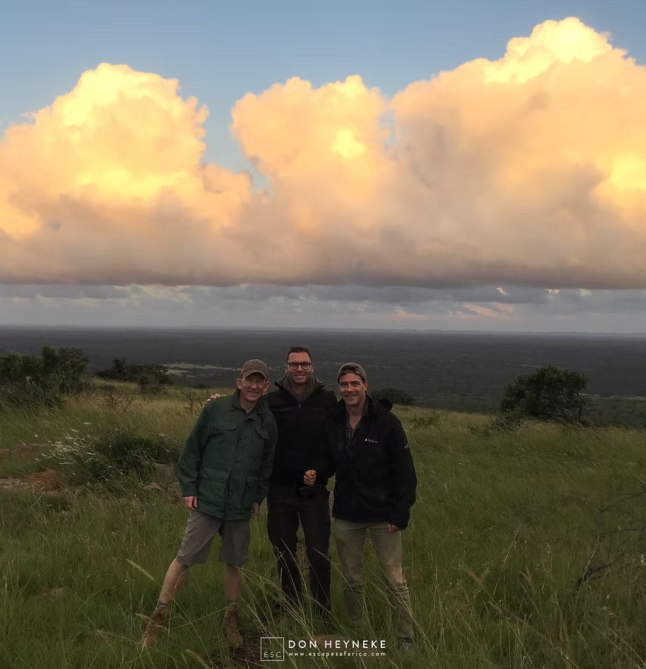 Guests and their guide on a ridge with storm cloud building behind