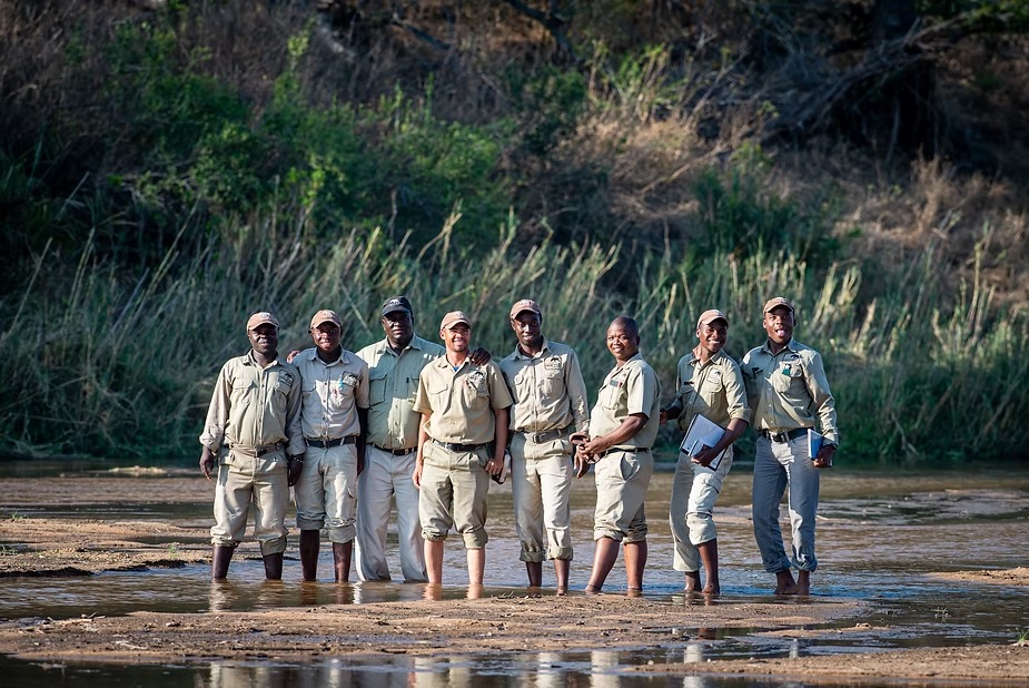 Camp staff lined up along the riverbank