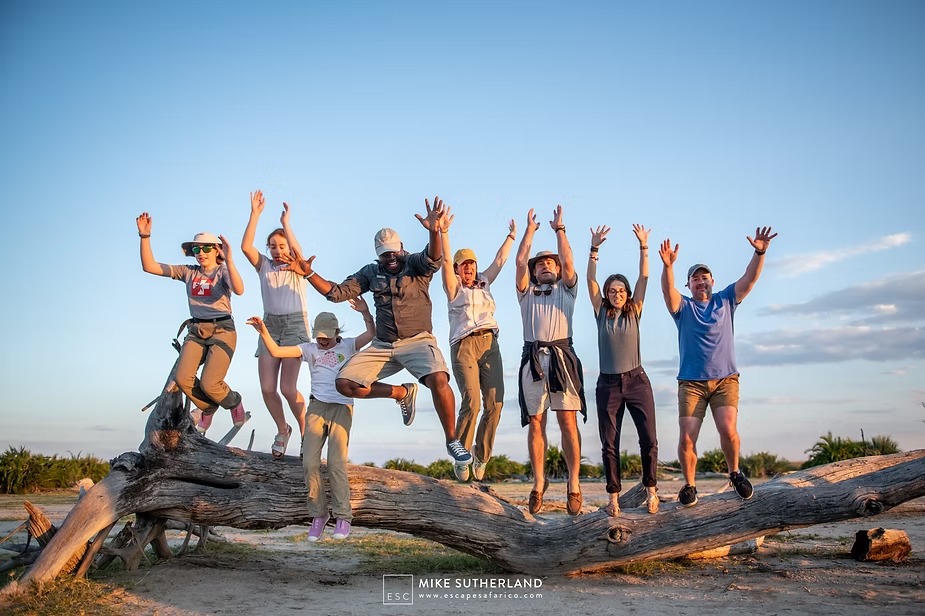 The Wilkens family jumping off a fallen tree at sunset