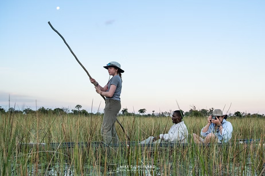 A guest taking a turn at poling the mokoro