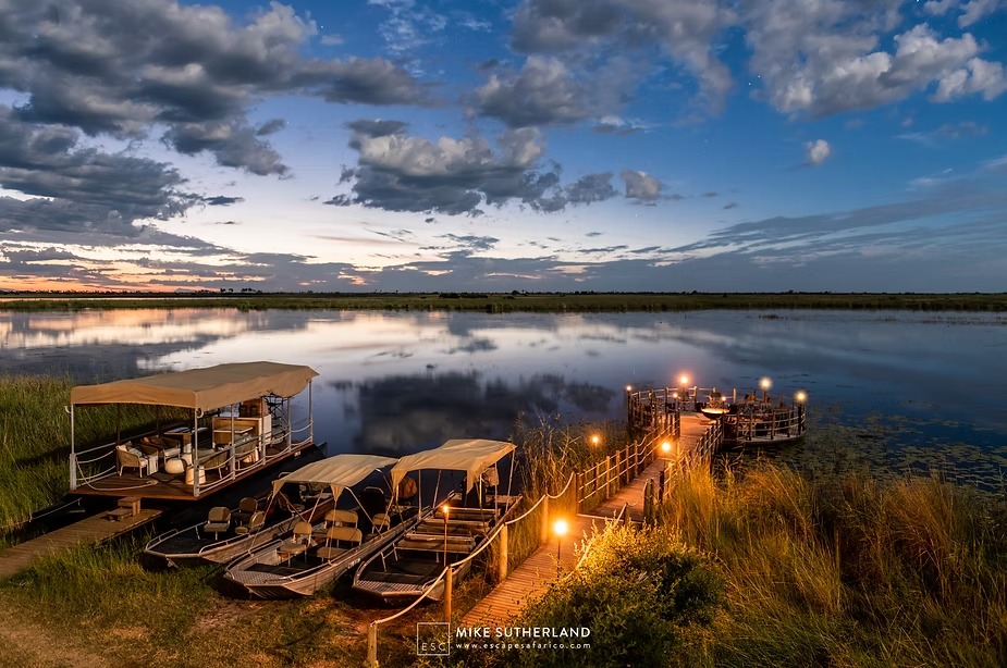 The jetty and boats lit at dusk beside the lagoon