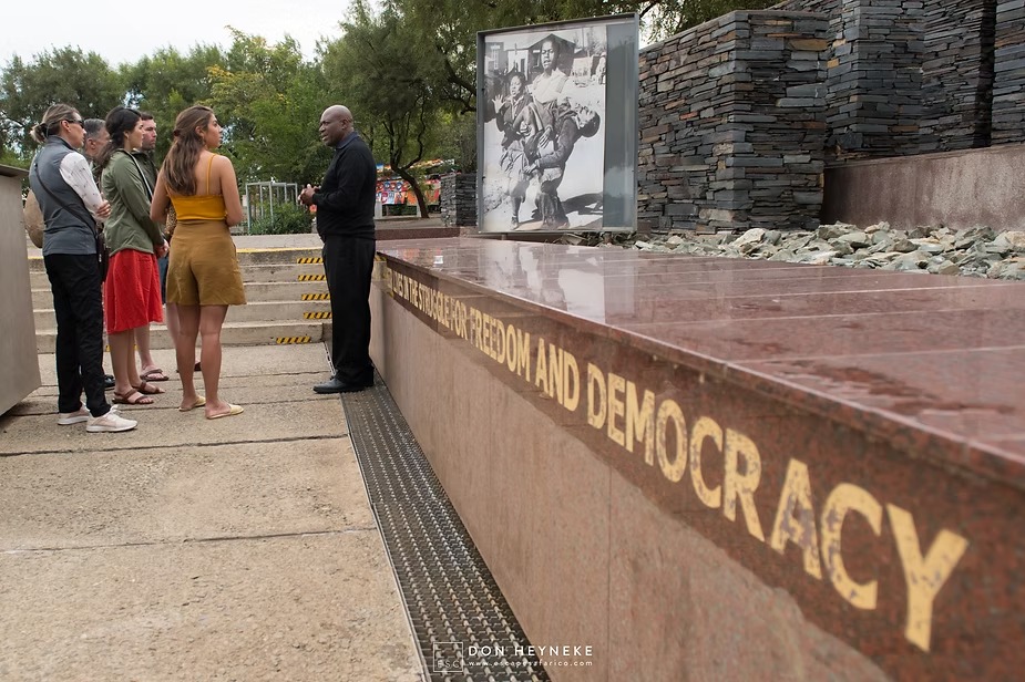 A guide talking the family through a memorial to freedom and democracy in Johannesburg