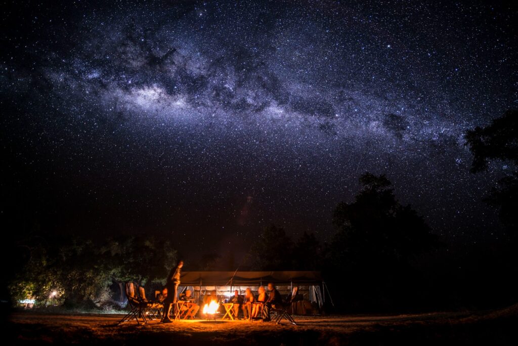 The Milky Way above a camp, the kind of night shot the guide explains how to take