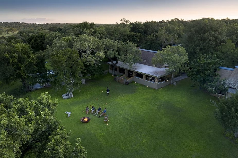 Singita Castleton seen from above, guests gathered at the fire on the lawn