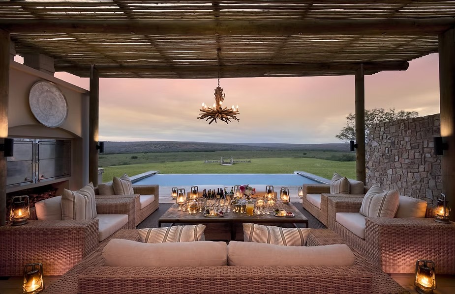 A candlelit table laid in the open lounge at Kwandwe Fort House
