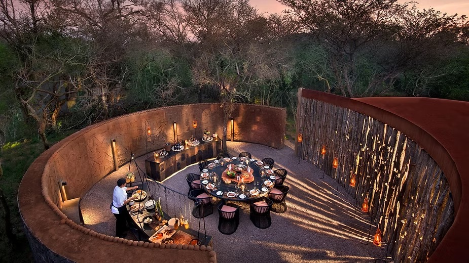 A candlelit dinner set in the round in the boma at Phinda Homestead