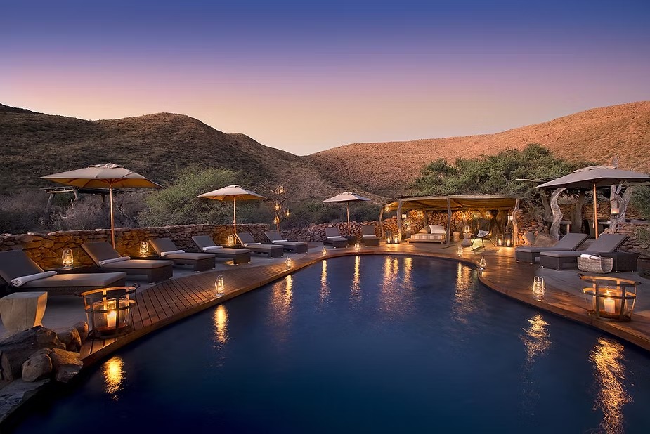 The pool at Tarkuni lit at dusk in the Kalahari at Tswalu