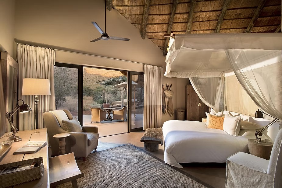 A four-poster suite at Tswalu's Tarkuni opening on to its private deck