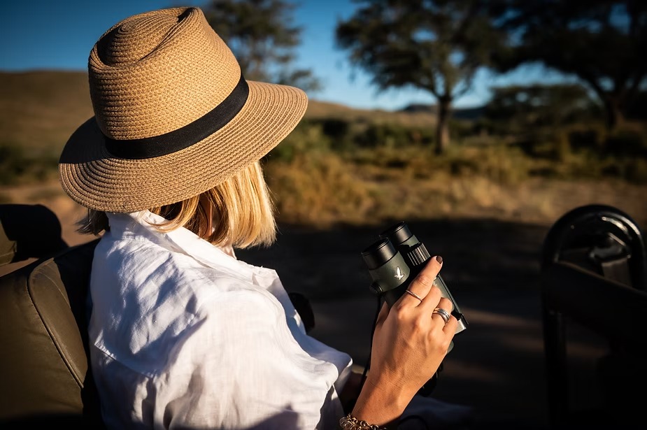 A guest with binoculars in the game vehicle