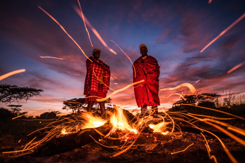 Maasai guides beside the fire at a Kicheche fly camp in the Masai Mara