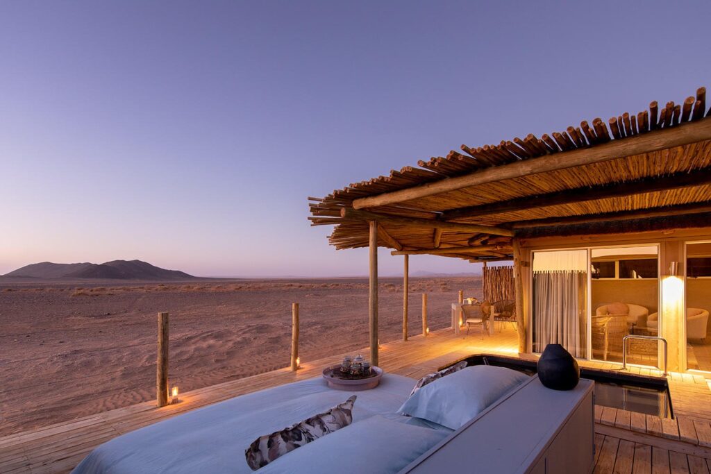 A star bed made up on the rooftop deck at Little Kulala, looking out over the Namib