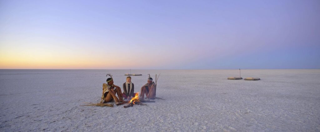 Guests sitting out on the Makgadikgadi salt pan at dusk near Meno a Kwena